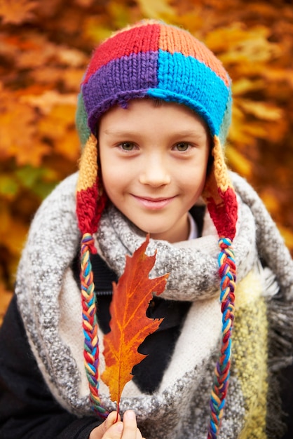 Ritratto di ragazzo che tiene una foglia d'autunno