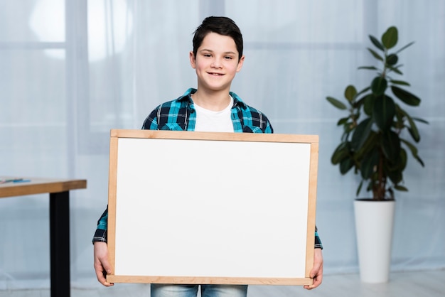 Free photo portrait boy holding frame