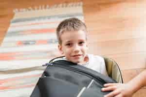 Free photo portrait of a boy sitting in the luggage