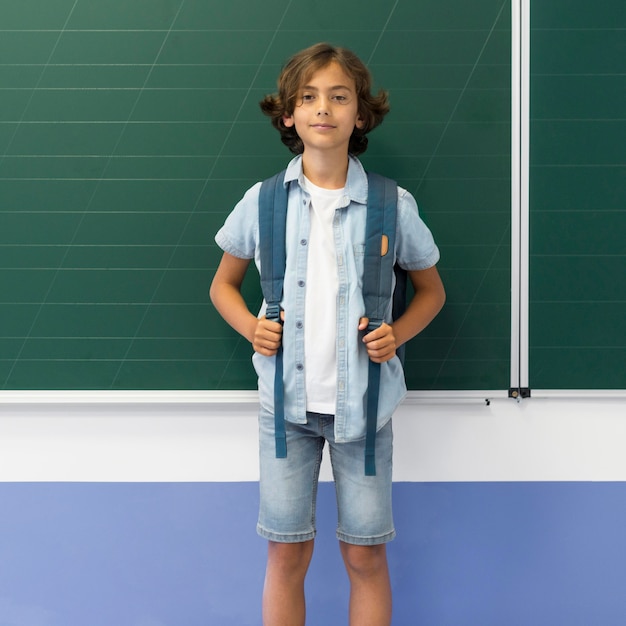 Portrait boy with backpack in class