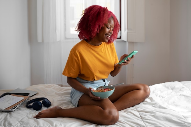 Portrait of braless woman at home using smartphone