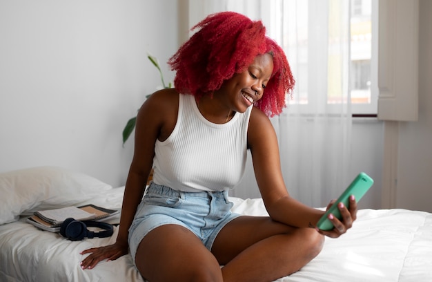 Portrait of braless woman at home using smartphone