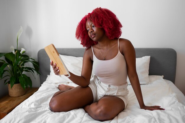 Free photo portrait of braless woman at home using tablet