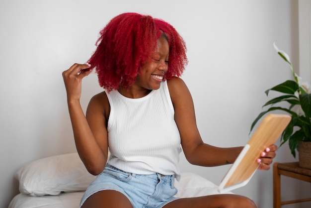 Portrait of braless woman at home using tablet