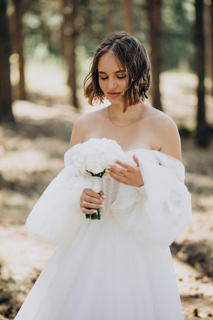 Portrait of bride in wedding dress in forest