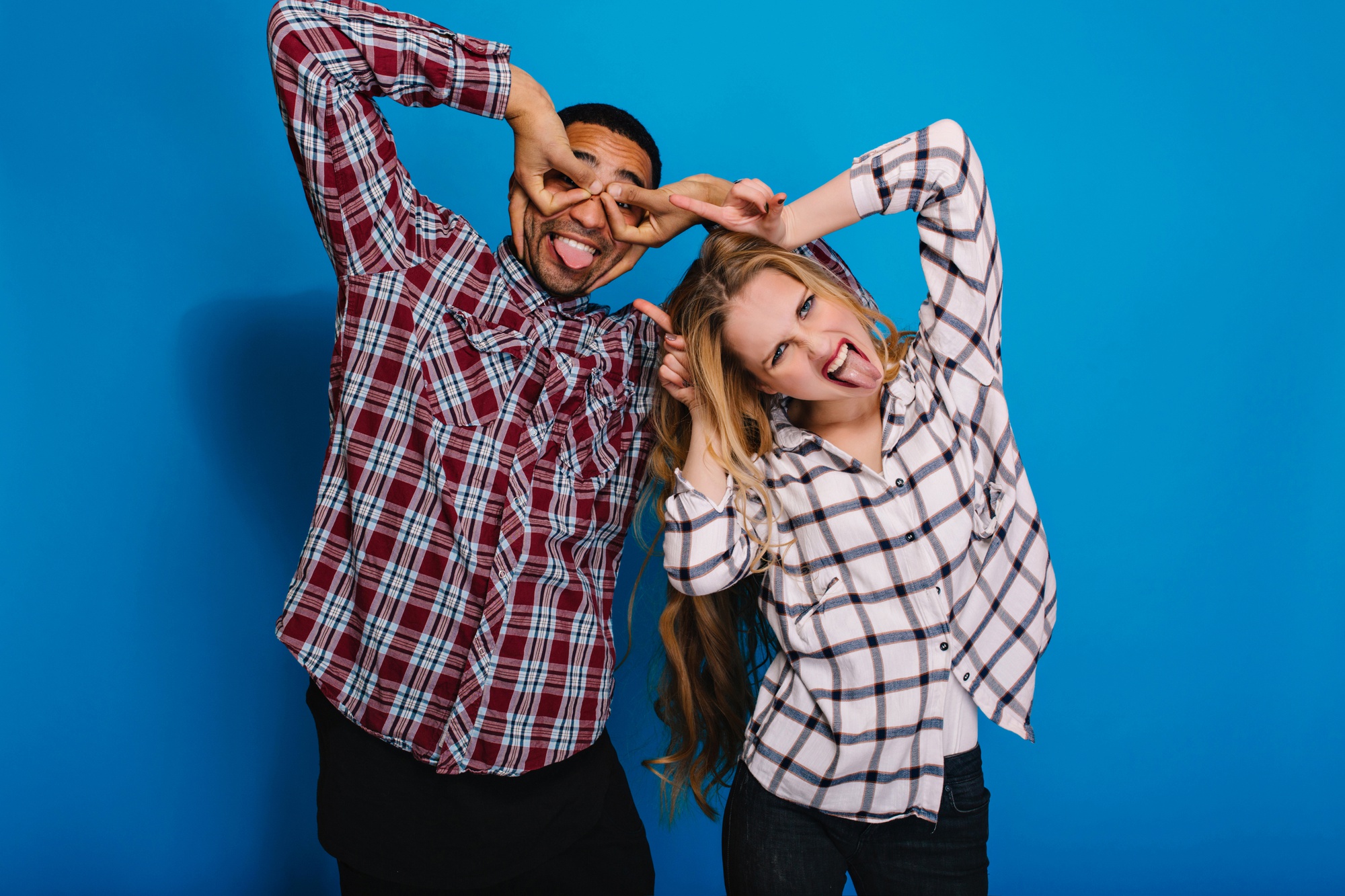 Portrait brightful positive emotions of funny excited couple fooling around. Having fun, free time, showing tongue, caper, monkey, funny.