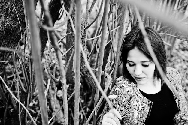 Portrait of brunette girl in black dress at spring wood