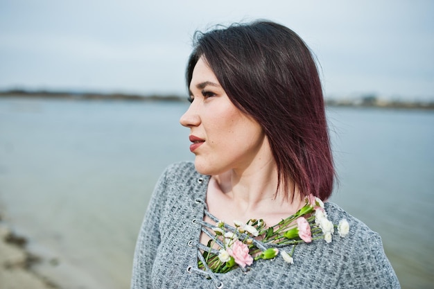 Free photo portrait of brunette girl in gray dress background the lake