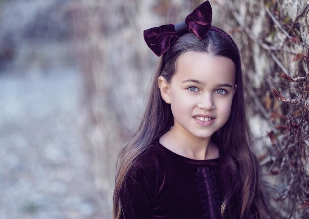 Portrait of brunette teenager female over grey rock.