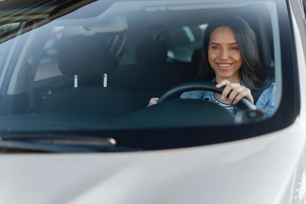 Free photo portrait of brunette woman in her car