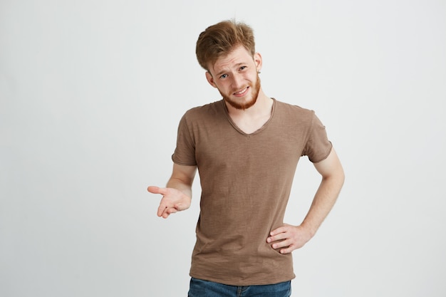 Portrait of brutal young handsome man with arms akimbo gesturing.