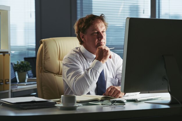 Portrait of business executive busy reading financial report 