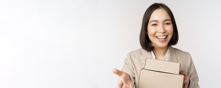 無料Photo 白い背景の上にスーツに立っている注文とボックスを与えるあなたを指しているビジネス女性アジアのセールスウーマンの肖像画