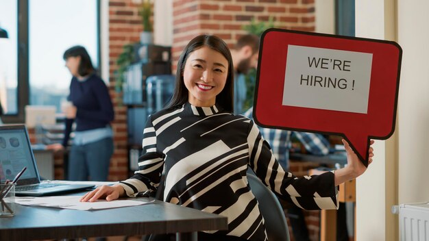 Portrait of business woman holding speech bubble to show job offer, advertising hiring and recruitment. Female employee using text message board to give business career opportunity.