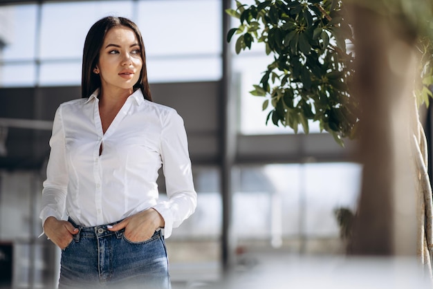 Portrait of business woman in white shirt standing in office