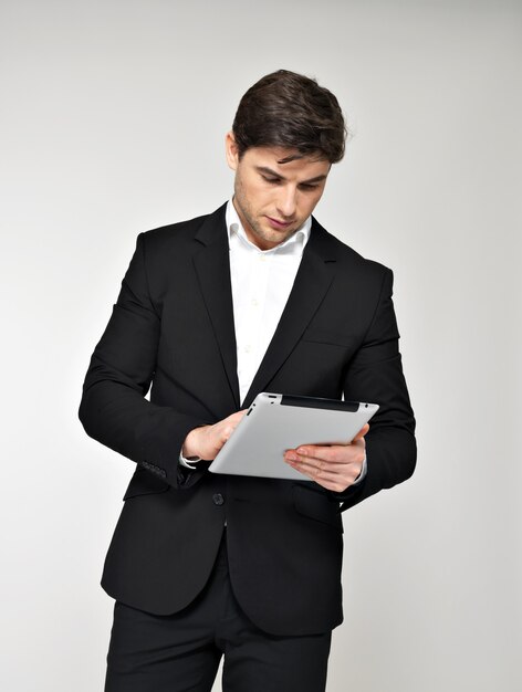 Portrait of businessman in black suit with pad. Concept communication.
