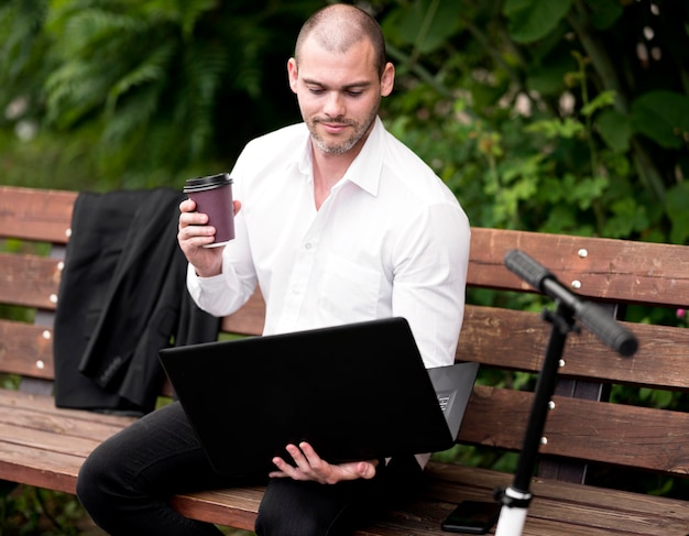 Free photo portrait of businessman browsing laptop outdoors
