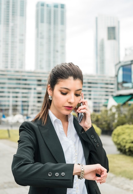 Portrait of a businessman checking time on her wrist watch