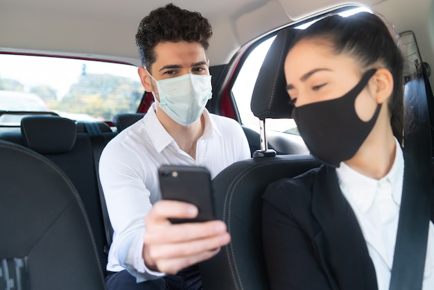 Portrait of businessman showing something on his phone to the cab driver. Business concept