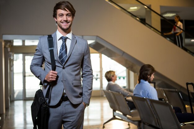 Portrait of businessman standing in waiting area