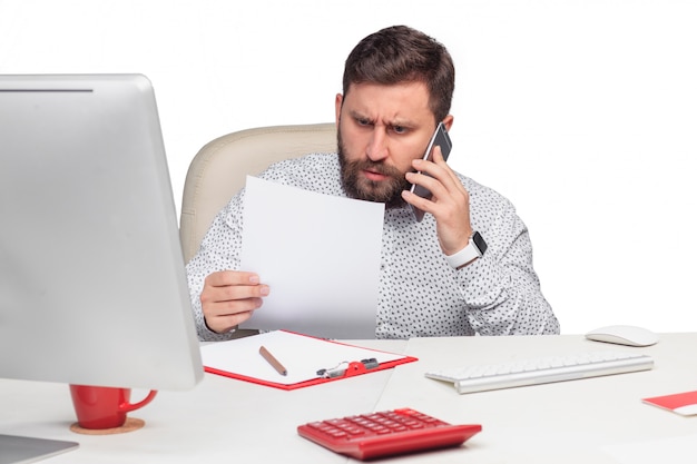 Portrait of businessman talking on mobile phone in office