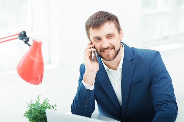 Free photo portrait of businessman talking on phone in office