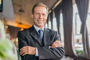 Free photo portrait of a businessman with folded arms looking at camera