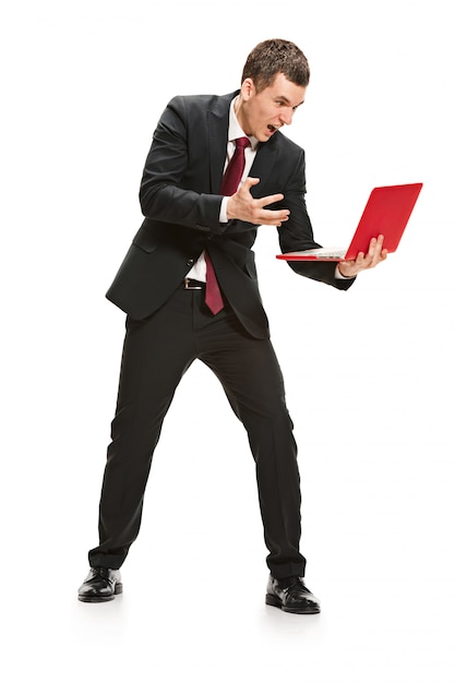 Portrait of businessman with laptop on white wall