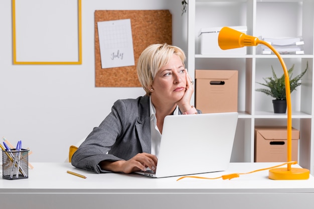 Free photo portrait of businesswoman at desk