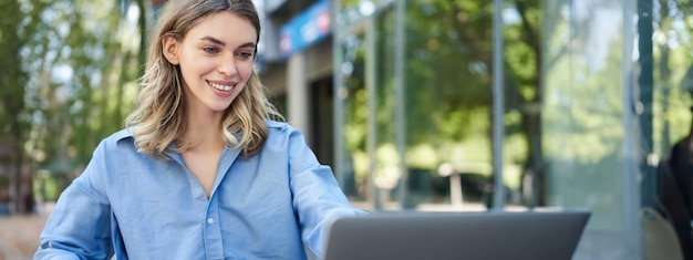 Free photo portrait of businesswoman working with laptop corporate woman using computer outdoors attend video