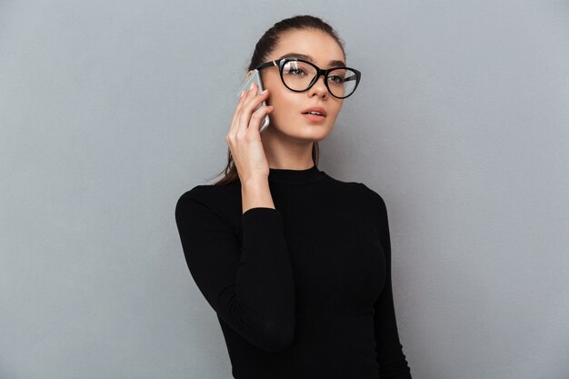 Портрет занятой молодой женщины в очках говорить