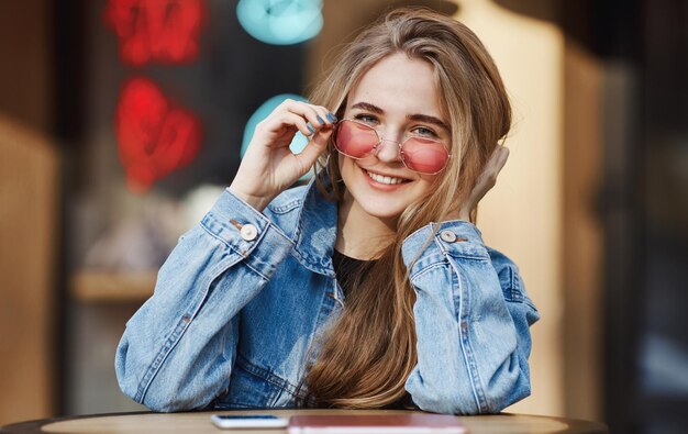 Portrait of candid blond girl waiting for her takeout order near