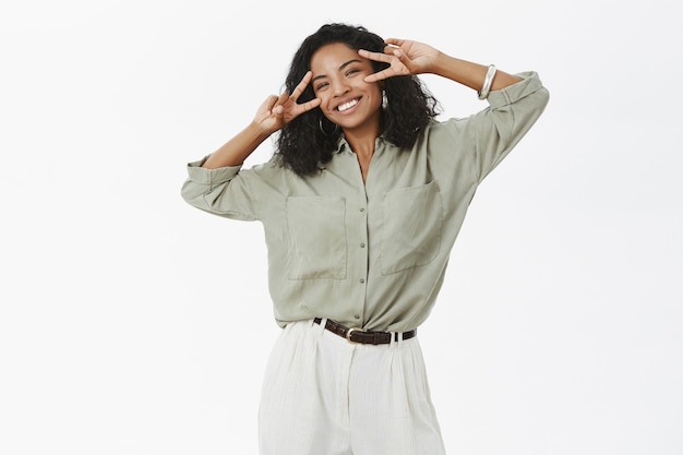 Portrait of carefree charming and upbeat young african american sucessful female in blouse and pants