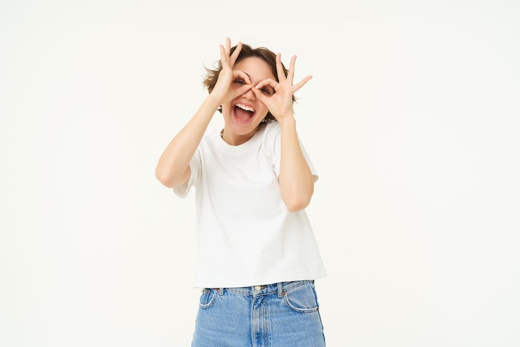 Free Photo portrait of carefree european woman showing glasses with hands over eyes and smiling posing over