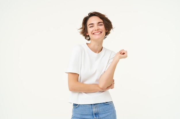 Foto gratuita ritratto di donna spensierata che ride posando con fiducia guardando sicura di sé e sorridente in piedi