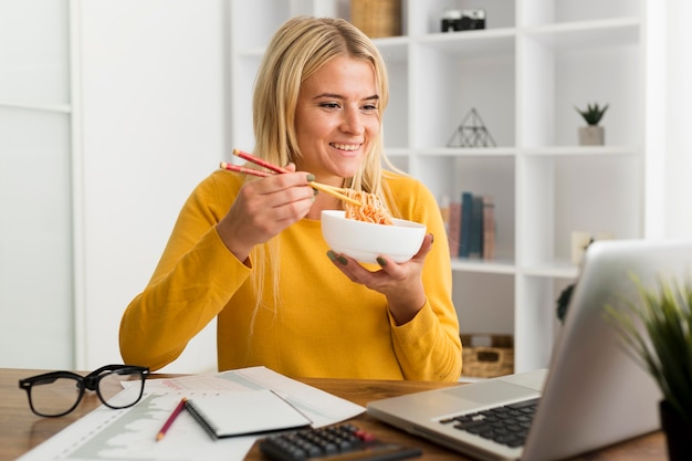 Foto gratuita ritratto di donna casual che mangia a casa