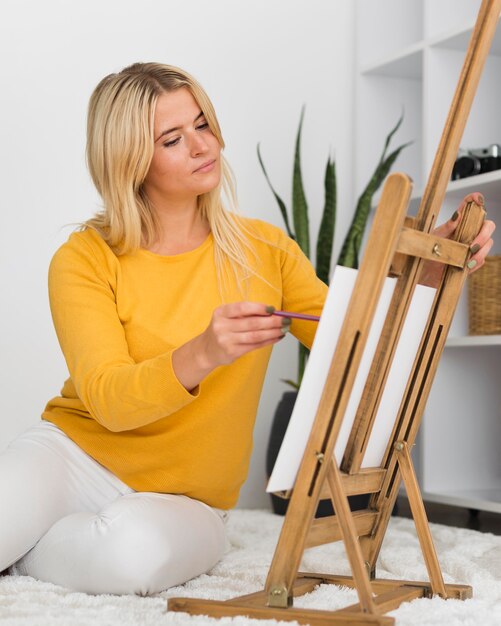 Portrait of casual woman painting at home