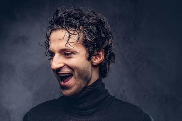 Portrait of a charismatic sensual male in black sweater with wet