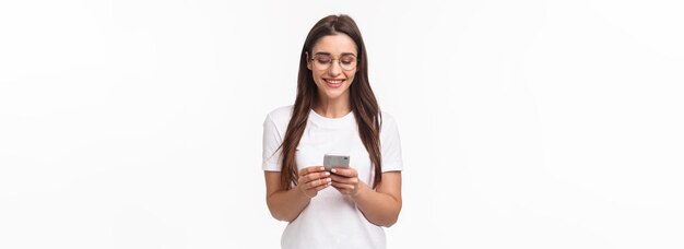 友人とチャットする smarphone を保持している携帯電話を使用してカリスマ的な笑顔の幸せな女性の肖像画