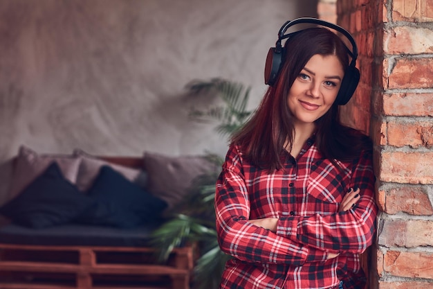 Portrait of a charming brunette in a flannel shirt and jeans lis