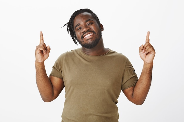 Portrait of charming guy in a brown t-shirt posing against the white wall