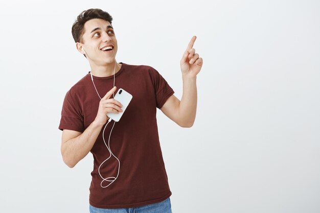 Portrait of charming impressed attractive male student in red t-shirt and jeans