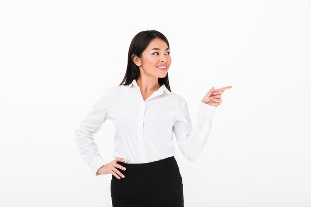 Portrait of a cheerful asian businesswoman pointing finger