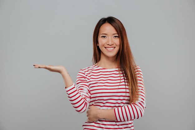 Portrait of cheerful asian woman holding copy space