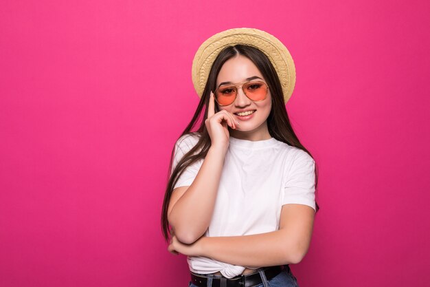 Portrait of a cheerful asian woman over pink wall.