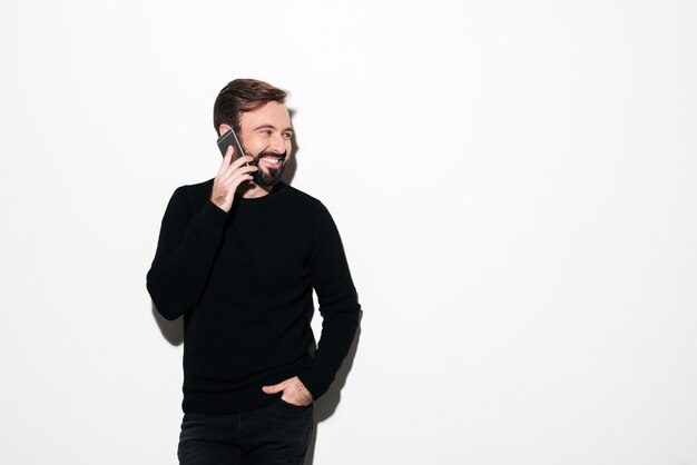 Портрет веселый бородатый мужчина разговаривает по мобильному телефону