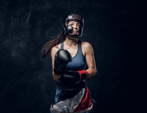 Portrait of cheerful boxer in protective helmet and gloves ready to fight.