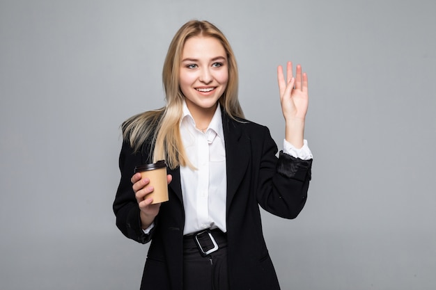 Portrait of a cheerful businesswoman holding cup with coffee.