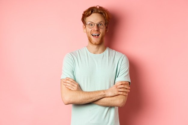 Portrait of cheerful european man in glasses looking amazed at camera see interesting promotion stan...