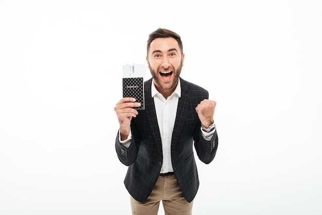 Portrait of a cheerful excited man holding passport